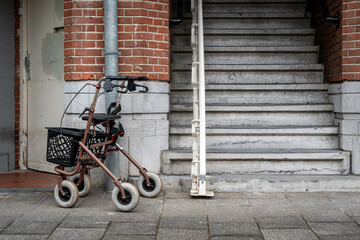 Mobility walker for elderly people in the street next to stair lift, rollator for seniors parked outside