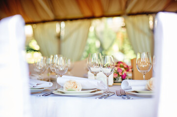 Elegant Outdoor Dinner Table Setting With Flowers and Glassware in Soft Lighting..