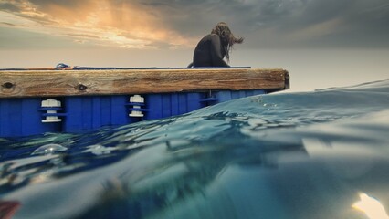girl diver sits on pontoon in sea