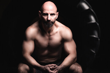 Senior crossfit male athlete posing in front of a Tire