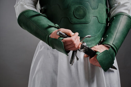 Assassin Knight. Male armoured hands holding steel whinger knife.