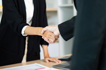 Business Partnership. Professional handshake between two women in a corporate setting.