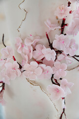 Wedding cake with delicate sugar cherry blossoms, beautifully handcrafted confectionery for a large event, 2 tiers cake with soft pink flowers and subtle gold cracks reminiscent of kintsugi artistry