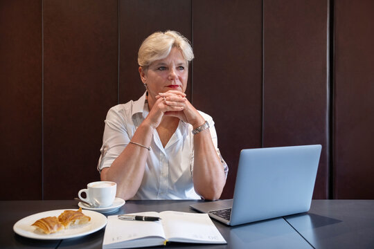 Confident middle-aged woman concentrating on her laptop while enjoying a coffee break, great representation of age diversity in the workplace, career success or digital literacy among mature adults