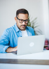 Professional Man Working on a Laptop in a Modern Office Setting