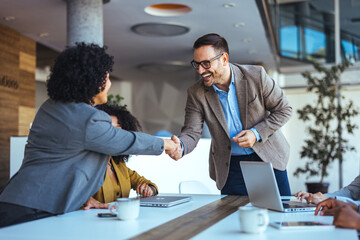 Business Professionals Shaking Hands During a Team Meeting in a Modern Office