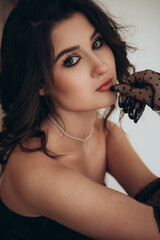 Glamorous brunette with black tulle gloves and soft light