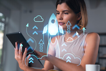 Smiling businesswoman in casual wear holding tablet device touching it at office workplace. Concept of distant work, business education, information technology. Start up hologram