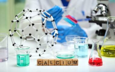 In a detailed lab scene, a crafted calcium model stands next to colorful solutions in various...