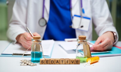 A clinician prepares sedatives using vials and essential medications laid out on the table for patient care