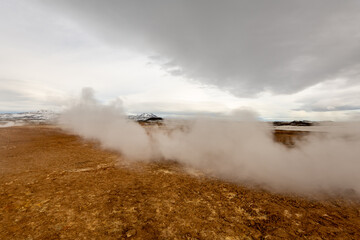 Geothermal Landscape in Icelandic Highlands with Steam Vents and Snow-Capped Mountains