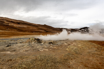 Geothermal Landscape in Icelandic Highlands with Steam Vents and Snow-Capped Mountains