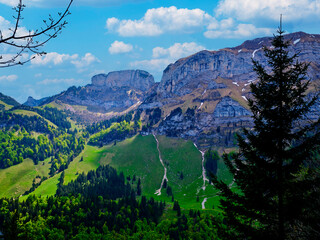 Spectacular mountain landscape view with green valleys and blue skies in the Swiss Alps during the daytime