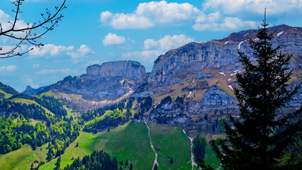 Stunning mountain landscape showcases rocky formations and lush greenery under a bright blue sky