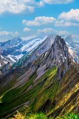 Majestic mountain landscape showcasing rugged peaks and lush green valleys under a blue sky