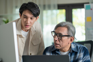 Programmer teaching programming to senior adult students, focusing on software development and coding techniques in a collaborative workshop.
