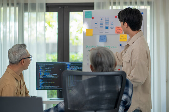 Teacher of  programmer teaching programming to college senior adult students, focusing on software development and coding techniques in a collaborative workshop."
