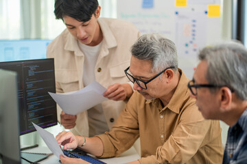 Obraz premium Asian developer leading a digital innovation class, teaching students about coding, software development, and web programming in a tech-savvy environment. 