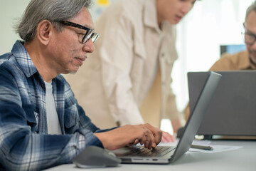 Obraz premium Retired engineer teaching coding to a diverse group of learners, focusing on web development and application programming in a relaxed workshop. 