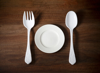 big plastic fork and spoon on dark wooden table