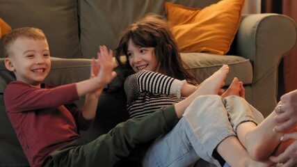 Happy children tickling and playing together on the floor - Powered by Adobe