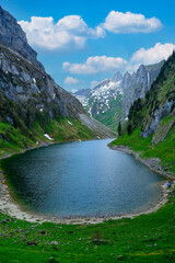Serene alpine lake nestled between majestic mountains on a sunny day
