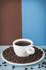 White Cup of Black Coffee with Roasted Beans on Solid Colored Background for Creative Branding