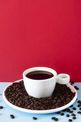 White Cup of Black Coffee with Roasted Beans on Solid Colored Background for Creative Branding