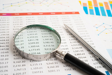 Magnifying glass on spreadsheet and graph paper. Financial data economy, Business.