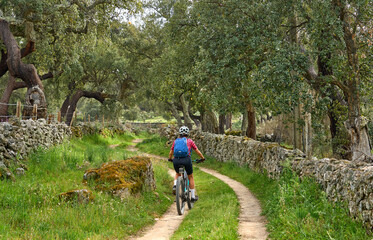 Obraz premium active senior woman cycling with her electric mountain bike in the rough landscape of National Parc Serra de São Mamede near Marvao in central Portugal, Europe