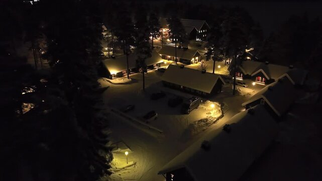 Drone approaching a cabin, in a Carelian Village, winter night in Kanuu, Finland