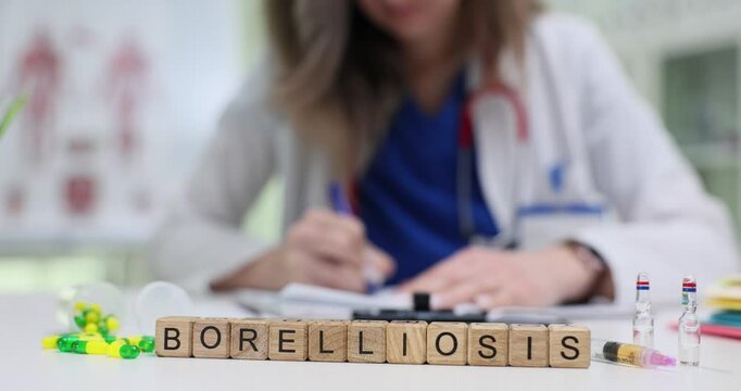 Doctor writes prescription for Borreliosis treatment near medication and syringe on table in medical office. Patient care and health management