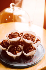 Freshly baked muffins displayed on a wooden table in a cozy cafe setting during the afternoon