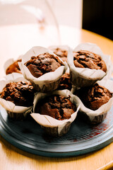 Freshly baked chocolate muffins on a wooden table in a cozy setting