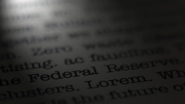 The Federal Reserve. US Economy. Moving text printed on a page. Headline. A piece of paper with a phrase written in retro typewriter font. Spotlight effect. Dramatic video.