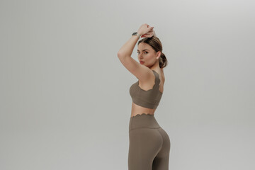 Model showcases activewear while preparing for fitness session in minimalistic studio setting