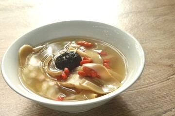 boiled slice Chinese bamboo shoot with goji berry and mushroom clear soup on bowl