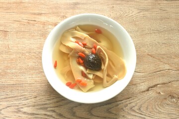 boiled slice Chinese bamboo shoot with goji berry and mushroom clear soup on bowl