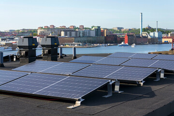 Solar panels on roof of apartment housing building with Gothenburg city center in background, Sweden, renewable green sustainable energy concept