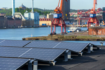 Solar panels on roof of apartment housing building with Gothenburg city center in background, Sweden, renewable green sustainable energy concept