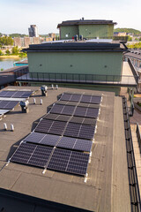 Solar panels on roof of apartment housing building with Gothenburg city center in background, Sweden, renewable green sustainable energy concept