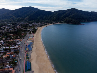 Obraz premium Beautiful coastal village with beautiful green water beach and tropical mountains around