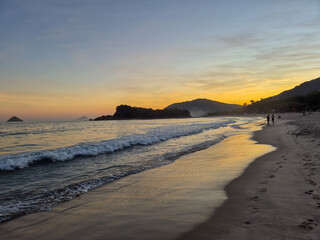 amazing red sunset among the rocks on a tropical beach