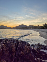amazing red sunset among the rocks on a tropical beach
