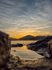 amazing red sunset among the rocks on a tropical beach
