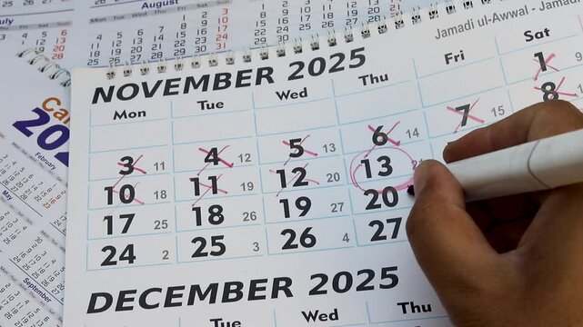 Circling date 13 November 2025 in a calendar with marker and writing call note.