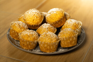 Delicious Homemade Muffins Topped with Powdered Sugar - Perfect for Breakfast or Snack, Freshly Baked and Ready to Enjoy on a Plate. Golden Hour Photo