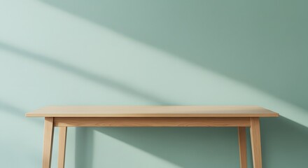 the minimalistic and peaceful vibe of the clean wooden table against a soft, sunlit green wall