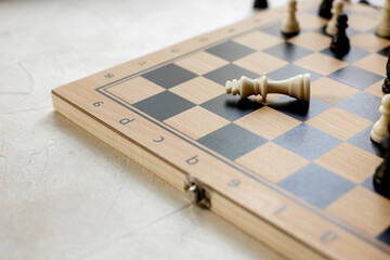 Checkmate. White king chess piece laying down on chessboard after checkmate