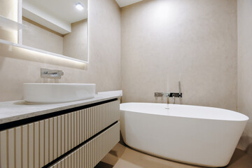 A bathroom that includes a bathtub, sink, and a mirror is present